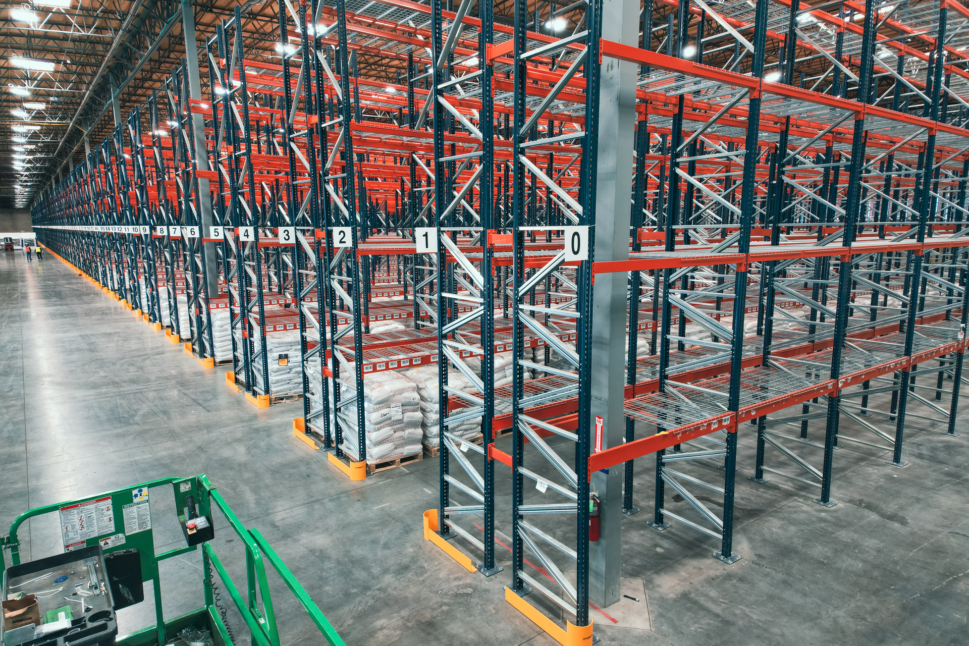 Long aisle of warehouse racking in a tall distribution building